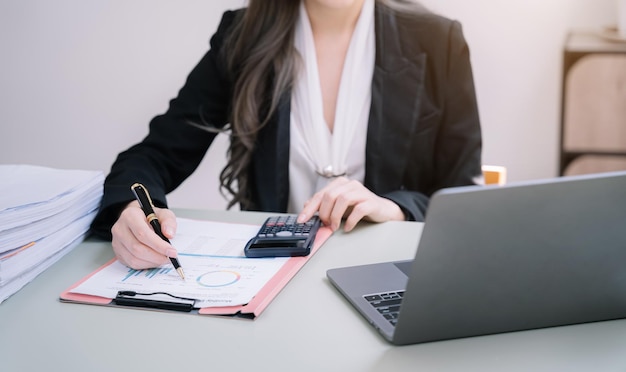 Geschäftsfrauen berechnen und analysieren Diagrammdokumentfinanzen mit Laptop im Büro
