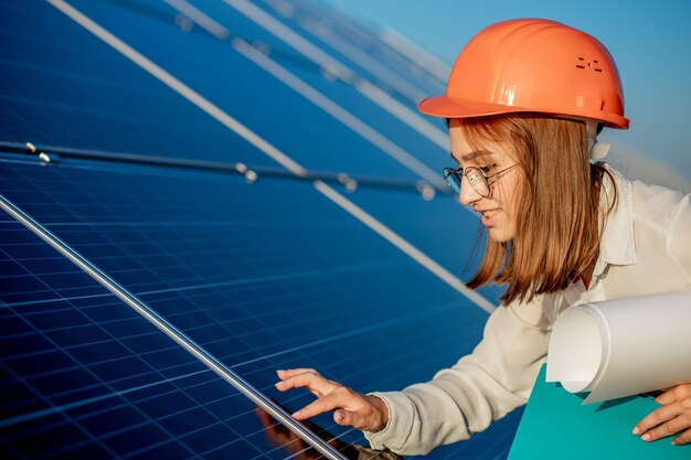 Geschäftsfrauen, die an der Überprüfung der Ausrüstung im Solarkraftwerk mit Tablet-Checkliste arbeiten, Frau, die im Freien am Solarkraftwerk arbeitet.