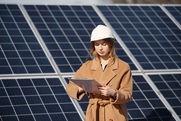 Geschäftsfrauen, die an der Überprüfung von Geräten im Solarkraftwerk arbeiten. Mit Tablet-Checkliste arbeitet Frau im Freien an Solarenergie.