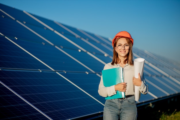 Geschäftsfrauen, die an der überprüfung der ausrüstung im solarkraftwerk mit tablet-checkliste arbeiten, frau, die im freien am solarkraftwerk arbeitet.