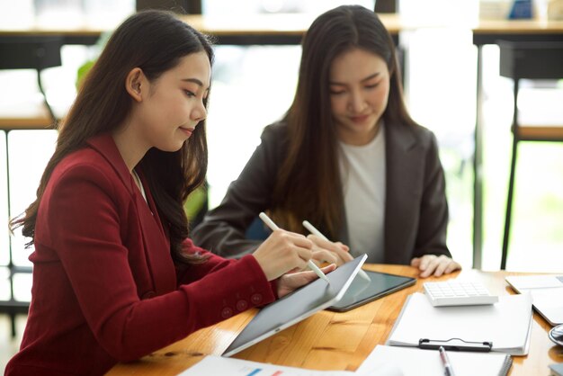 Geschäftsfrauen, die an ihrem modernen tragbaren Tablet-Computer im Coworking Space im Café arbeiten