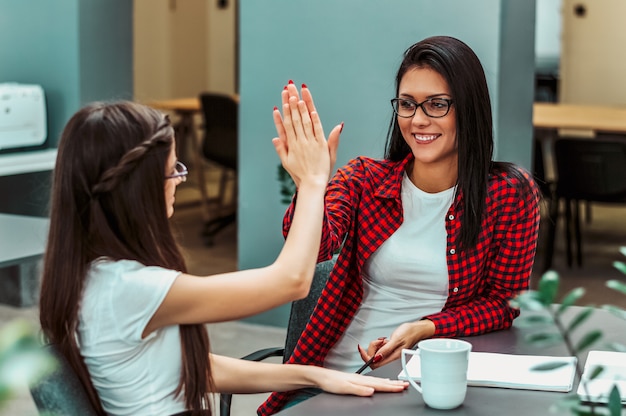 Geschäftsfrauen, die Erfolg im Büro feiern.