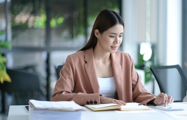 Geschäftsfrauen, die Taschenrechner bei der Arbeit mit Finanzberichten verwenden