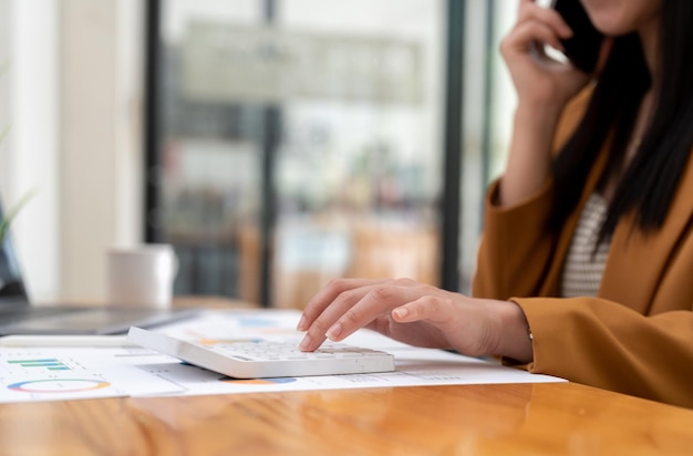 Geschäftsfrauen, die Taschenrechner mit Computer-Laptop verwenden Geschäftsbuchhaltungsbudget und Darlehenspapier im Büro, Nahaufnahme