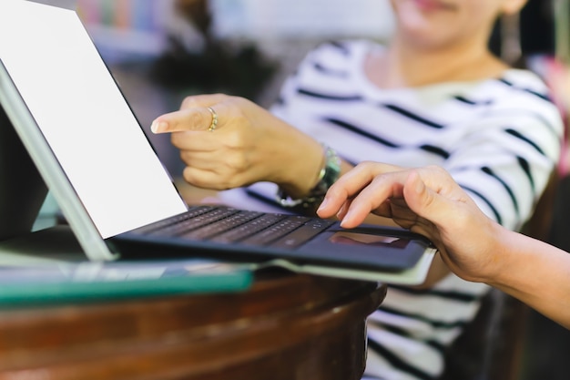 Foto geschäftsfrauen-teamarbeit, die am schreibtisch mit computer-laptop sitzt und im büro diskutiert