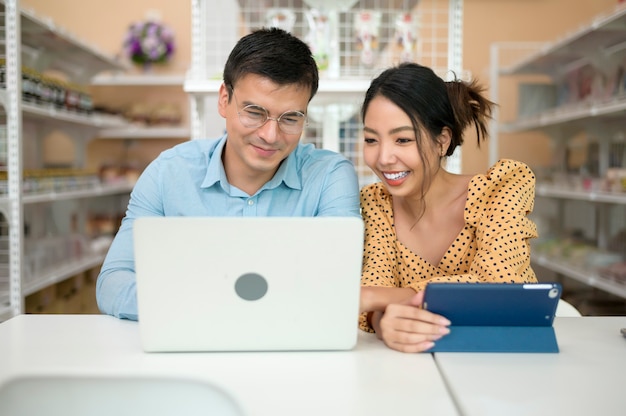 Geschäftsinhaber analysieren Geschäftsdaten, sprechen und lächeln in einem modernen Geschäft