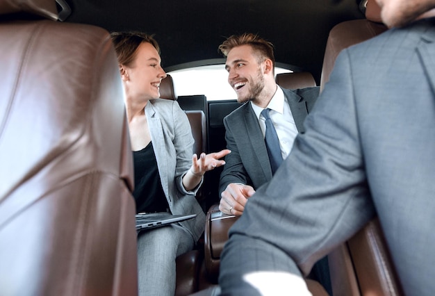 Geschäftskollegen besprechen etwas im Auto sitzend