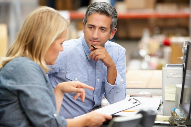 Geschäftskollegen, die am Schreibtisch im Lager arbeiten