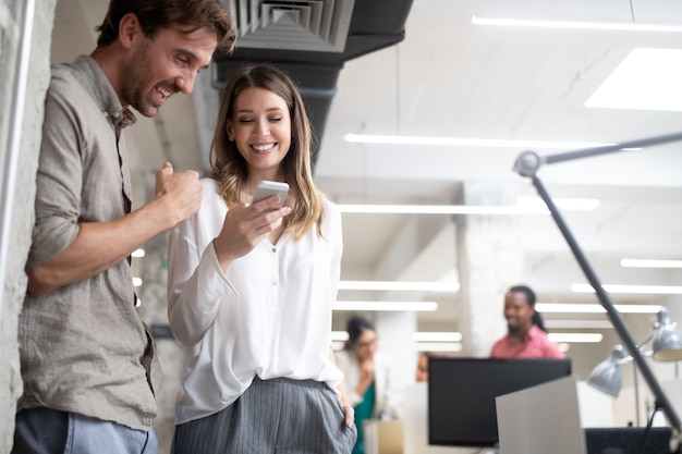 Geschäftskollegen, die Spaß haben und im Büro am Arbeitsplatz chatten