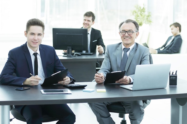 Geschäftskollegen sitzen an einem Schreibtisch im Büro