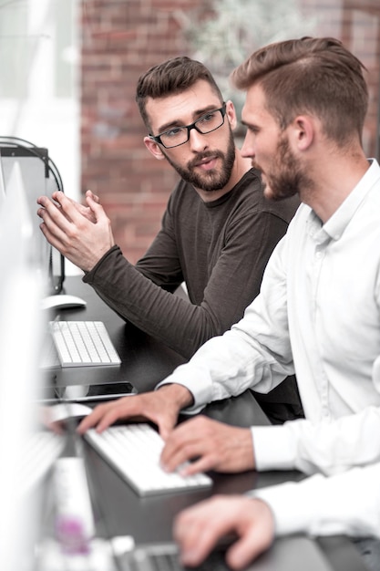 Geschäftskollegen unterhalten sich an einem Computertisch