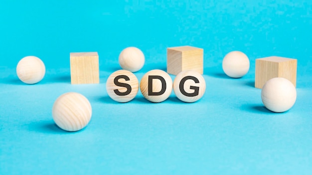 Geschäftskonzept auf den blauen Tischkugeln und Holzwürfeln mit der Aufschrift SDG