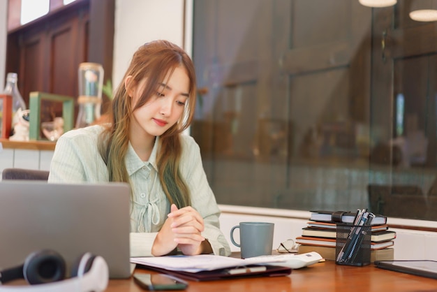 Geschäftskonzept Unternehmerin liest Dokument und trinkt Kaffee im Coworking Space Office