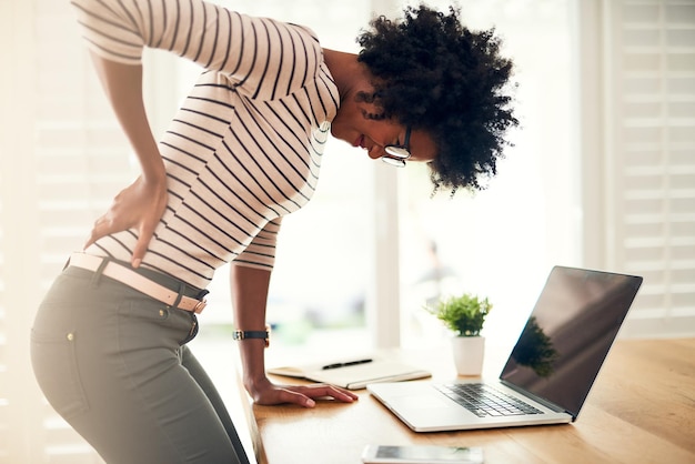 Foto geschäftslaptop und frau mit rückenschmerzen, burnout und gesundheitlichen problemen mit verletzung, unfall und entzündung. weibliche angestellte oder unternehmerin mit pc-technologie und medizinischem problem mit belastung