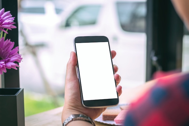 Geschäftsleute benutzen ein Smartphone und einen Laptop in einem Café