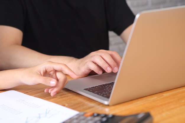 Geschäftsleute benutzen Laptop und Geschäftsberichtpapier auf hölzernem Schreibtisch mit Diskussion