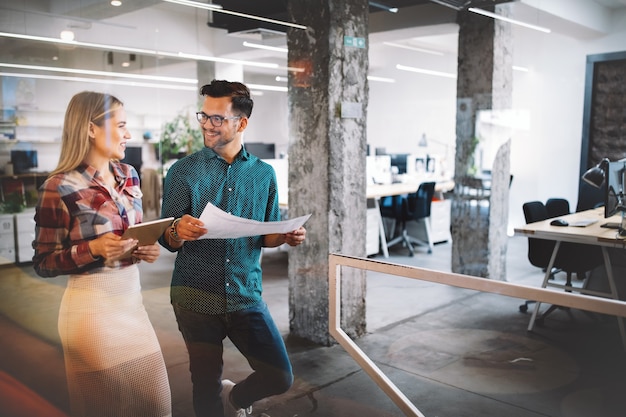 Geschäftsleute, Designer, die Spaß haben und im Büro am Arbeitsplatz chatten