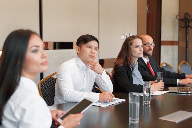 Geschäftsleute, die am Konferenztische zusammenarbeiten