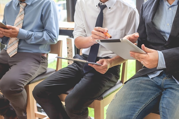 Geschäftsleute, die beim Arbeiten mit Finanzberichten und einer Tablette sich treffen.