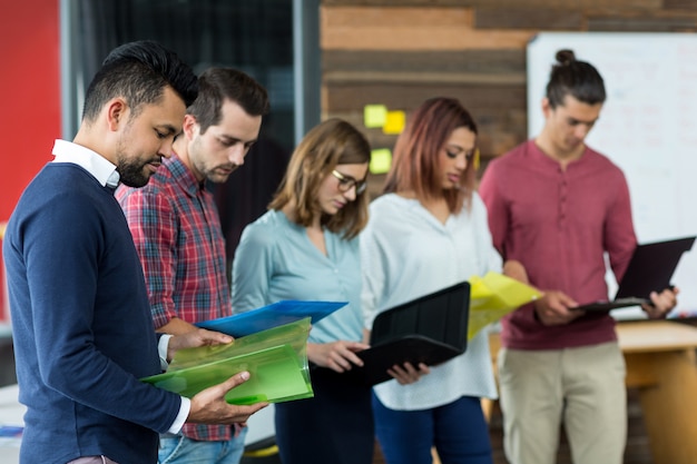 Geschäftsleute, die Datei im Büro überblicken