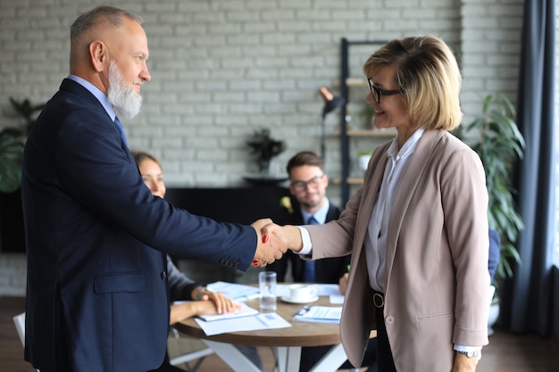 Geschäftsleute, die Hände schütteln, ein Meeting beenden.