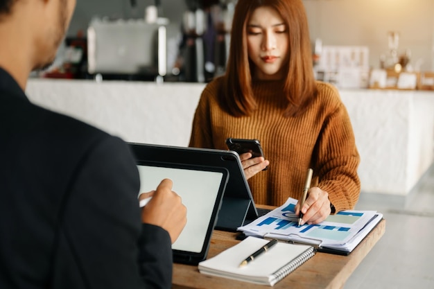 Geschäftsleute, die Präsentationen mit seinen Kollegen und Business-Smartphone-Tablet-Digitalcomputern als Besprechungskonzept machen