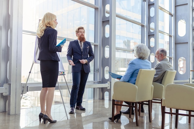 Geschäftsleute, die sich einem älteren Paar im Business Center, Investitionen, Investitionskonzept präsentieren