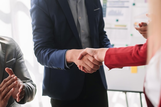 Geschäftsleute, die sich während eines Meetings im Büro die Hände schütteln