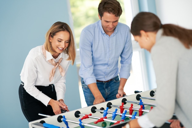 Geschäftsleute, die Tischfußball in gemeinsamen Büroräumen spielen