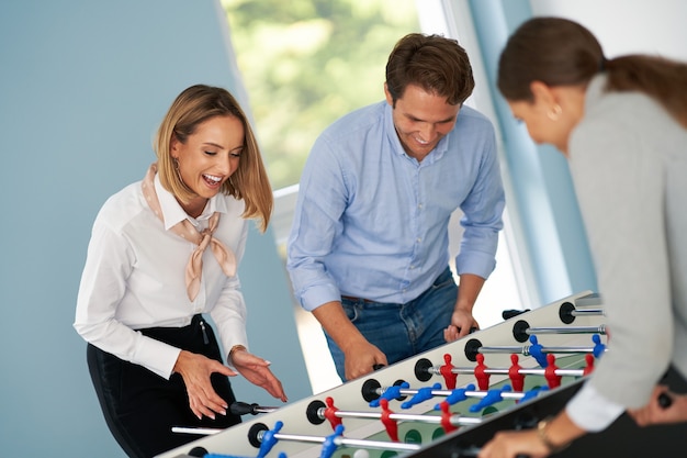 Geschäftsleute, die Tischfußball in gemeinsamen Büroräumen spielen