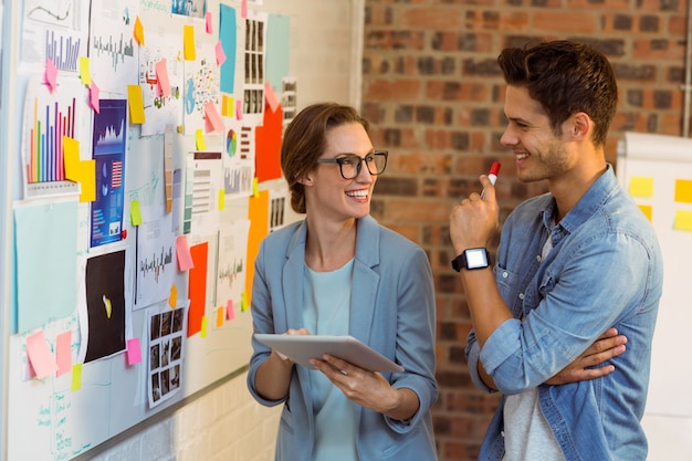 Geschäftsleute diskutieren über digitales Tablet in der Nähe von Whiteboard