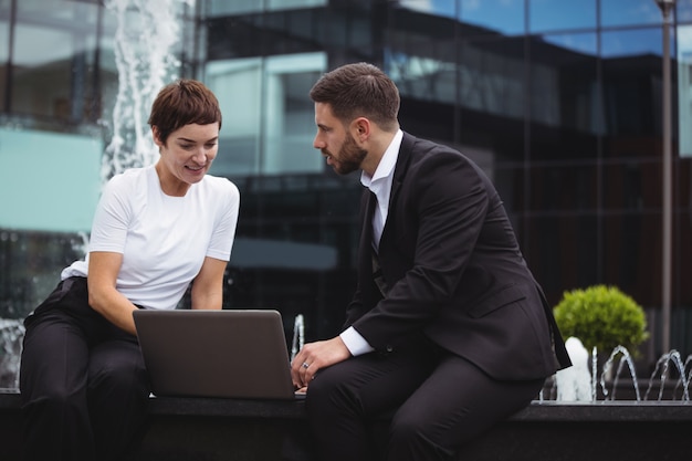 Geschäftsleute diskutieren über Laptop