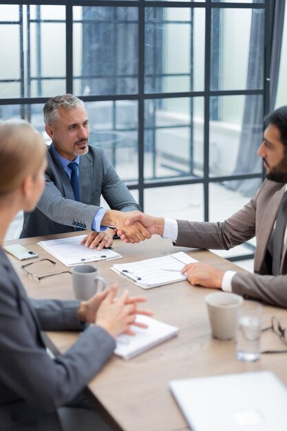 Geschäftsleute geben sich die Hand und beenden ein Meeting