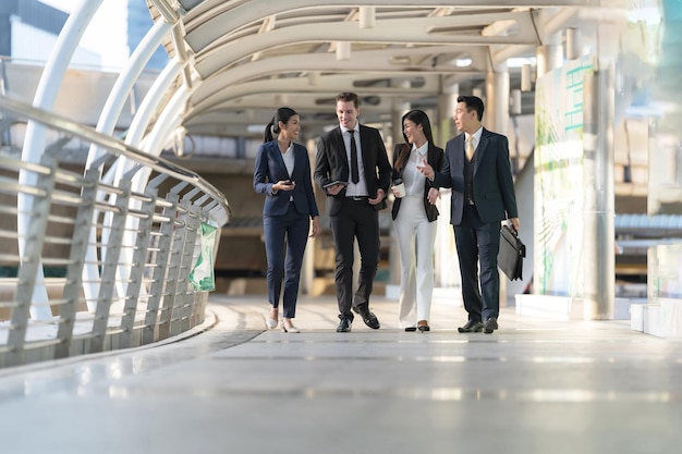 Geschäftsleute gehen und sprechen miteinander vor modernem Büro