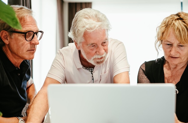 Geschäftsleute Gruppe reifer, selbstbewusster Geschäftsleute, die Daten mithilfe eines Laptops analysieren