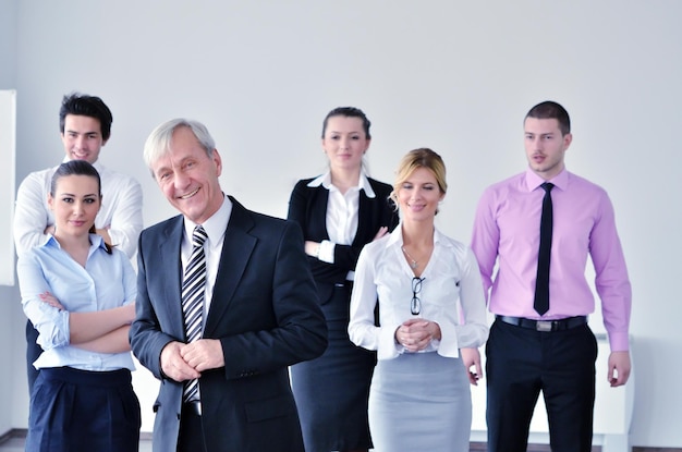 Geschäftsleute gruppieren sich bei einem Meeting in einer hellen und modernen Büroumgebung.