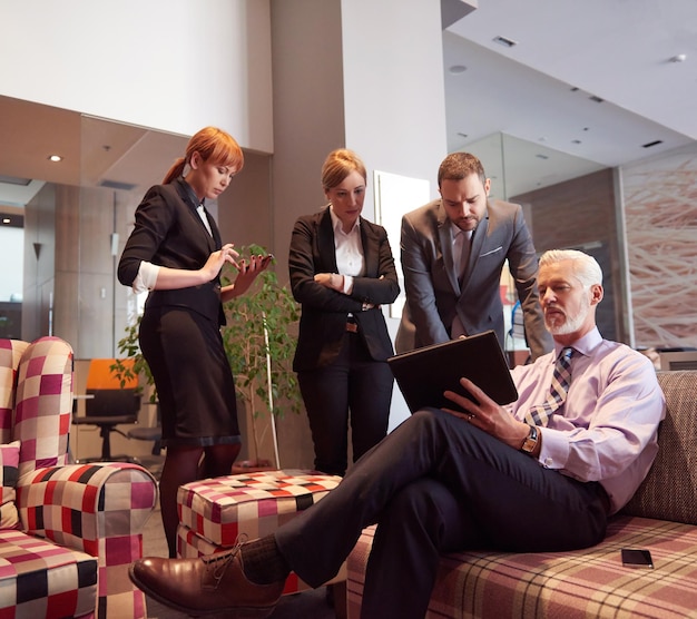 geschäftsleute gruppieren sich mit jungen erwachsenen und senioren bei einem treffen in einem modernen, hellen bürointerieur.