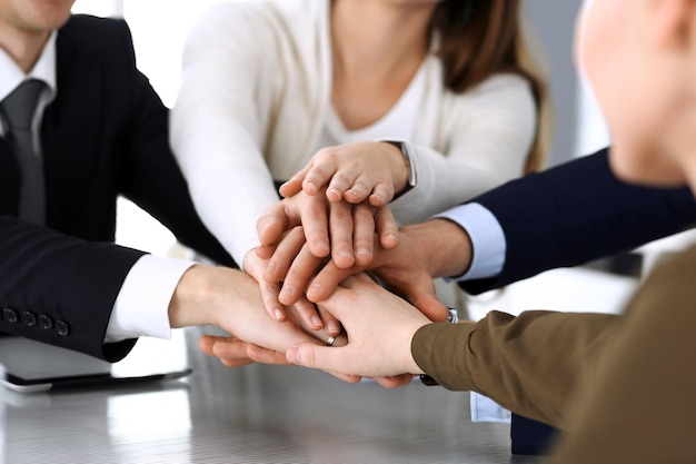 Foto geschäftsleute gruppieren teamwork und fügen sich die hände oder geben fünf nach vertragsunterzeichnung