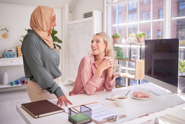 Geschäftsleute im Büro und Frauen unterhalten sich am Schreibtisch, plaudern oder diskutieren Besprechungskommunikation und glücklicher Manager in zwanglosen Gesprächen mit Mitarbeitern oder Kollegen in der Pause am Arbeitsplatz des Unternehmens