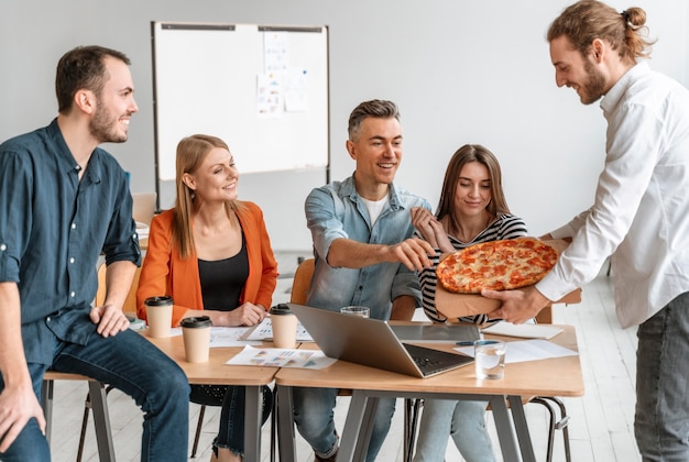 Geschäftsleute in der Mittagspause essen Pizza