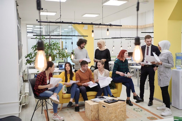 Geschäftsleute in modernen Büros haben ein Teammeeting und Brainstorming, während sie an Tablets oder Laptops arbeiten, Ideen präsentieren und Notizen machen