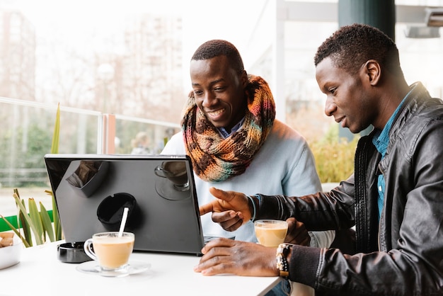 Geschäftsleute mit Handy und Laptop im Café. Geschäftskonzept