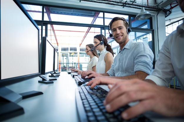 Geschäftsleute mit Headsets, die Computer verwenden