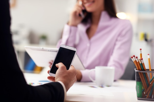 Geschäftsleute mit Smartphones im Büro