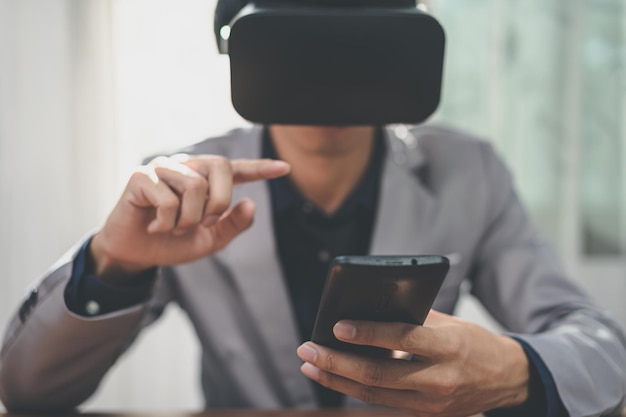 Geschäftsleute nutzen Smartphones mit Virtual-Reality-Brille in der Online-Welt des virtuellen Metaverses.