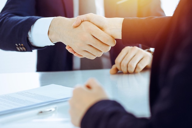 Foto geschäftsleute oder anwälte schütteln sich die hand, um ein treffen oder eine verhandlung in einem sonnigen büro zu beenden.