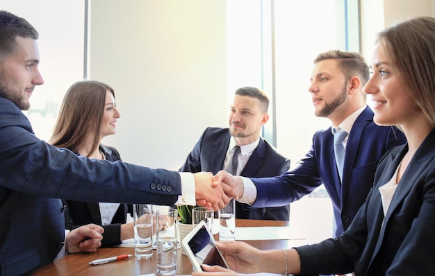 Geschäftsleute schütteln sich die Hände und beenden ein Meeting