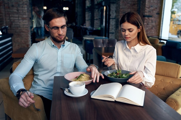 Geschäftsleute sitzen mit dem Telefon am Tisch und unterhalten sich beim Frühstück