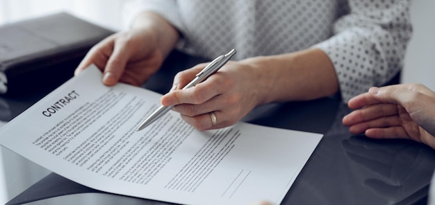 Geschäftsleute sitzen und diskutieren Verträge im Büro, Nahaufnahme. Partner oder Anwälte arbeiten bei einem Treffen zusammen. Teamarbeit und Partnerschaft.