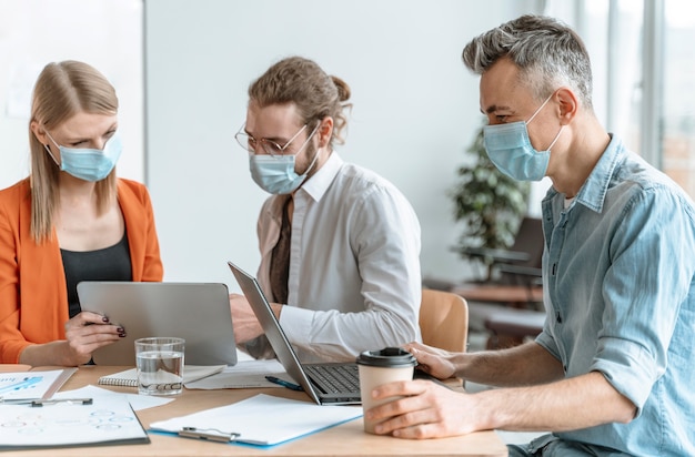 Geschäftsleute treffen sich im Büro mit Masken